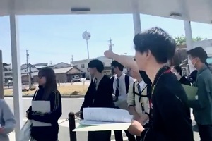 新城駅前の桜の看板の説明を受けている写真