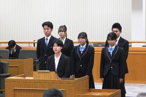 余暇・趣味・居場所委員会のメンバーが議場の質問席で話している写真