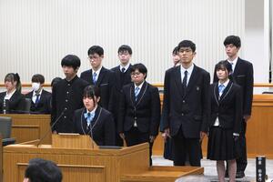 新城広め隊委員会のメンバーが議場の質問席で話している写真