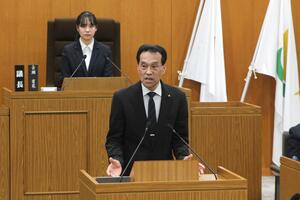 市議会議長が演台であいさつしている写真