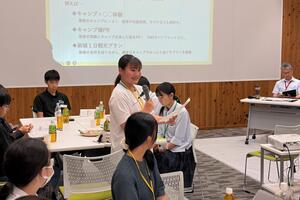 グループ内のメンバーが全体に向けて話している写真