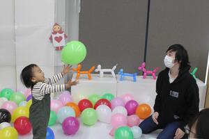 子どもが風船に囲まれて楽しんでいる写真