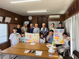 地域の活動団体の人たちと中学生がワークショップで使った模造紙を持って撮影した集合写真